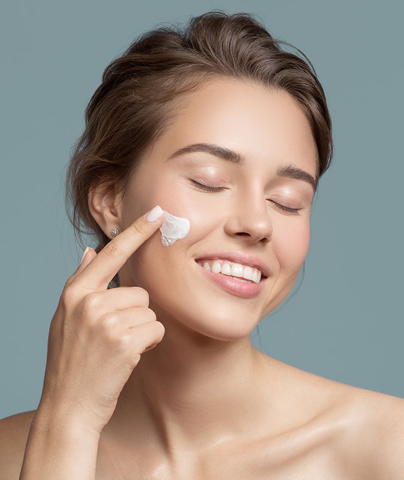 Una mujer aplicándose crema facial
